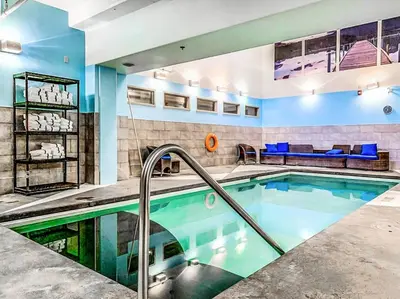 a swimming pool in a room with a couch and a couch at Cozy 2BR Retreat Mountain View with Pool and Hot Tub in Canmore