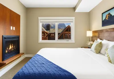 a bedroom with a bed and a fireplace at Spacious Rockies Escape near Banff Hot tub and Gym in Canmore