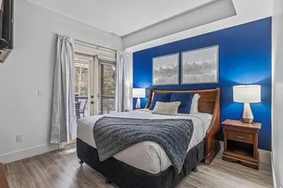 a bedroom with a blue accent wall and a bed at Spacious 2BR Oasis with Pool and Gym Close to Banff in Canmore