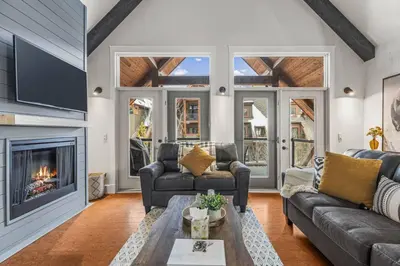 a living room with a couch and a fireplace at Mountain View Penthouse with Pool and Hot Tub in Canmore
