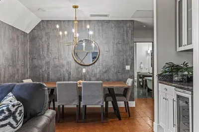 a dining room with a table and a couch at Mountain View Penthouse with Pool and Hot Tub in Canmore