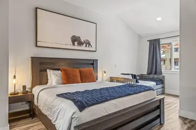 a bedroom with a large bed and a picture of elephants at Mountain View Penthouse with Pool and Hot Tub in Canmore