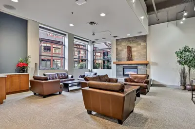 a lobby with leather furniture and a fireplace at Mountain View Penthouse with Pool and Hot Tub in Canmore