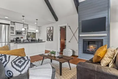 a living room with a couch and a fireplace at Mountain View Penthouse with Pool and Hot Tub in Canmore