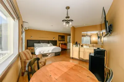 a bedroom with a bed and a table in a room at Similkameen Valley Resort in Cawston