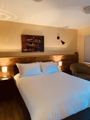 a bedroom with a large white bed with two lamps at Similkameen Valley Resort in Cawston