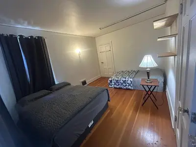a bedroom with two beds and a table with a lamp at Vancouver Guest House - Airport 10 Min, Downtown 15 Min - Free Parking & Fast Wi-Fi in Vancouver