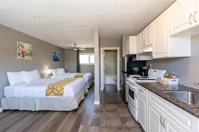 a bedroom with a large bed and a kitchen at Hinton Highway Inn in Hinton