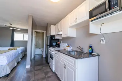 a kitchen with a sink and a bed in a room at Hinton Highway Inn in Hinton