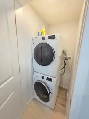 a washing machine with a microwave on top of it at Amaville - Two BRM Suite in West Edmonton in Edmonton