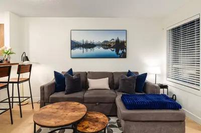 a living room with a couch and a table at Private Hot Tub | Pool | Free Parking | Sauna in Whistler