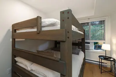 a wooden bunk bed in a room with a window at Private Hot Tub | Pool | Free Parking | Sauna in Whistler