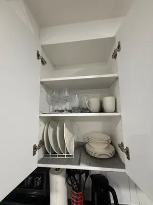 a kitchen pantry with plates and glasses on shelves at Cozy 2 Bedroom Suite Close to Amenities in Edmonton