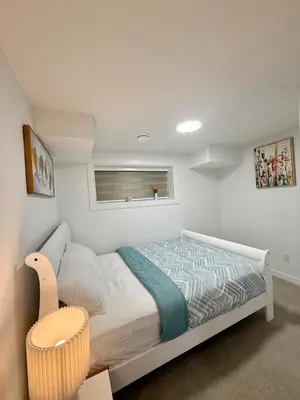 a small bedroom with a bed and a window at Cozy 2 Bedroom Suite Close to Amenities in Edmonton