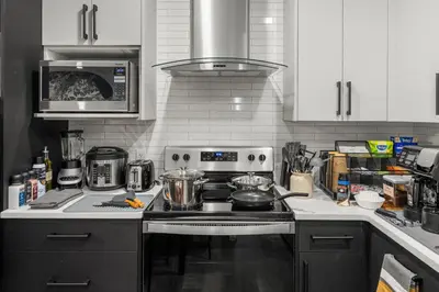 a kitchen with a stove with pots and pans on it at King Bed, Full Kitchen, Free Parking, Family Friendly Dining, Workspace & Fast Wi-fi - Private Basement Suite in Calgary