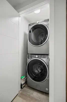 two washing machines and a dryer in a room at King Bed, Full Kitchen, Free Parking, Family Friendly Dining, Workspace & Fast Wi-fi - Private Basement Suite in Calgary