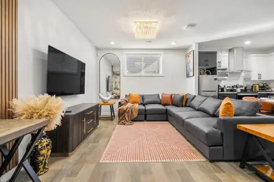 a living room with a couch and a flat screen tv at King Bed, Full Kitchen, Free Parking, Family Friendly Dining, Workspace & Fast Wi-fi - Private Basement Suite in Calgary