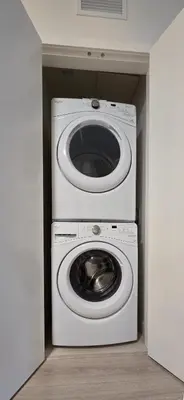 a white washer and dryer in a small room at Parkside at Waterfront in Downtown Calgary in Calgary