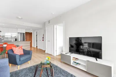 a living room with a large flat screen tv at Parkside at Waterfront in Downtown Calgary in Calgary