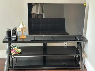 a black entertainment center with a television on top at Bright & Cozy 1B1B in Vancouver-close to YVR Airport & DT, Free Parking, Private Entrance, in Vancouver