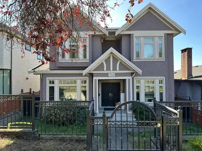 a house with a black fence in front of it at Bright & Cozy 1B1B in Vancouver-close to YVR Airport & DT, Free Parking, Private Entrance, in Vancouver