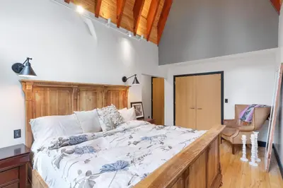 a bedroom with a large bed with a wooden headboard at Luxury Whistler 6BR Chalet, Hot Tub and Music Loft in Whistler
