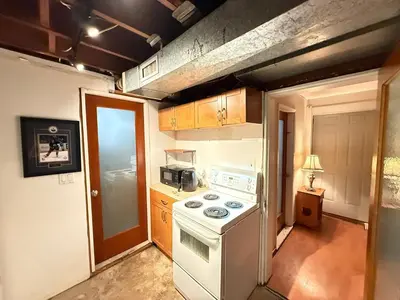 a small kitchen with a white stove top oven at Downtown Central City Cozy Private 2 Bedroom Basement Suite - Independent Entry in Surrey