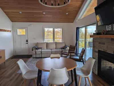 a living room with a couch and a fireplace at Serenity on the Vista's Point at Lac La Nonne in Onoway