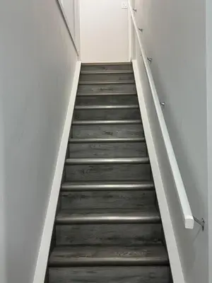 a stairway leading up to a room with white walls at Modern comfort just 20 minutes from the airport, with a full kitchen in Edmonton