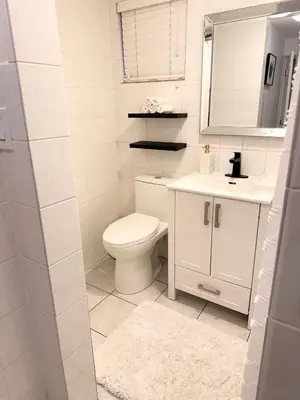 a white bathroom with a toilet and a sink at Newly Renovated - Self contained Suite - Sleeps 6 in Vancouver