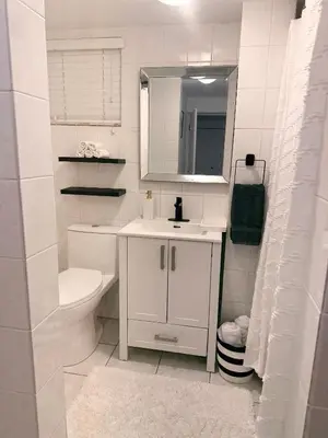 a white bathroom with a sink and a toilet at Newly Renovated - Self contained Suite - Sleeps 6 in Vancouver