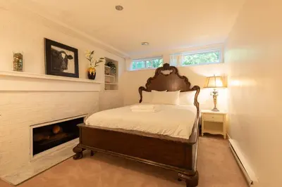 a bedroom with a bed and a fireplace at South Vancouver Garden Home in Vancouver