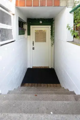 a white front door of a house with stairs at South Vancouver Garden Home in Vancouver