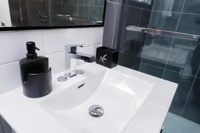 a bathroom sink with a black soap dispenser on it at Superior and Spacious 2-bedroom basement private suite in Edmonton