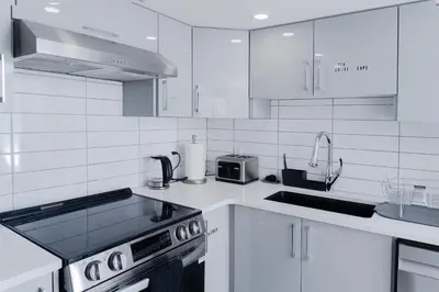 a white kitchen with a stove and a sink at Superior and Spacious 2-bedroom basement private suite in Edmonton