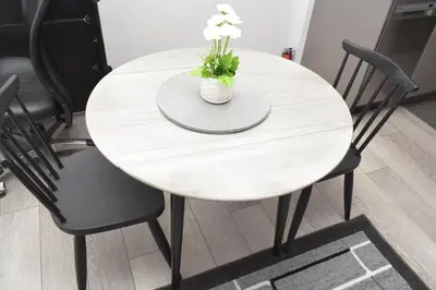 a white table with a vase of flowers on it at Beautiful Basement Suite in Stillwater, West Edmonton in Edmonton