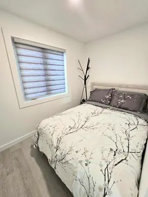 a bedroom with a bed and a window at The Oasis in Stettler in Stettler