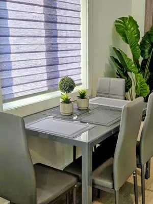 a dining room table with two chairs and plants at The Oasis in Stettler in Stettler