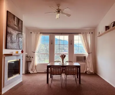 a dining room with a table and chairs and a fireplace at Stunning Mountain View in Fairmont Hot Springs