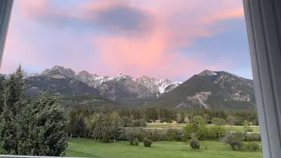 a view of a mountain range with a rainbow at Stunning Mountain View in Fairmont Hot Springs