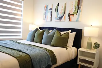 a bedroom with a bed with blue and white pillows at Seton 4BR Family Home 5 Min to South Campus in Calgary