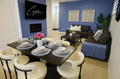 a dining room and living room with a table and chairs at Seton 4BR Family Home 5 Min to South Campus in Calgary