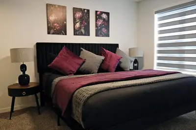 a bedroom with a large bed with purple sheets and pillows at Seton 4BR Family Home 5 Min to South Campus in Calgary