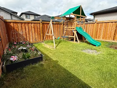a backyard with a playground and a slide at Chappelle with AC King Beds Fenced Yard Garage in Edmonton