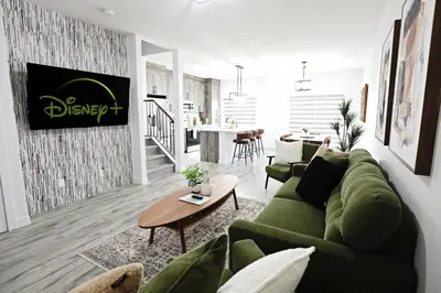 a living room with a green couch and a table at Chappelle with AC King Beds Fenced Yard Garage in Edmonton