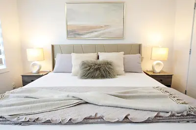 a bedroom with a large white bed with two lamps at Chappelle with AC King Beds Fenced Yard Garage in Edmonton