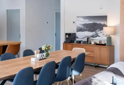 a dining room with a wooden table and blue chairs at CAPOW House in Revelstoke