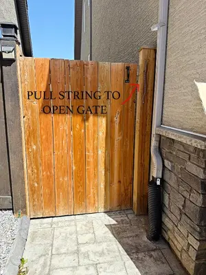 a wooden gate with a sign that reads pull string to open gate at Mahogany Lakefront 2BR Walkout Trails And Privacy in Calgary