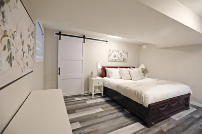 a bedroom with a bed and a door in it at Mahogany Lakefront 2BR Walkout Trails And Privacy in Calgary