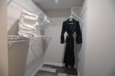 a black coat hanging on a rack in a closet at Mahogany Lakefront 2BR Walkout Trails And Privacy in Calgary